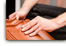 Mann mit Dachziegel in der Hand